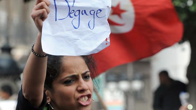 Janvier 2011. Une jeune manifestante dans les rues de Tunis appelle à la démission du président Ben Ali. [Fethi Belaid]