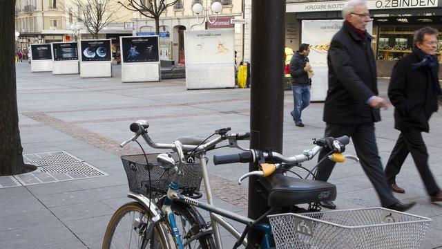 Des personnes passent vers l'exposition "Genève, ville vivante". [Salvatore Di Nolfi]