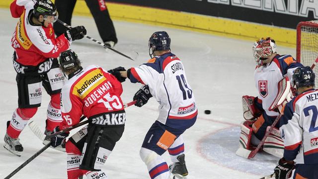 Damien Brunner enfile le troisième but à Hudacek. L'après-midi fut belle pour l'attaquant zougois et l'équipe de Suisse face à la Slovaquie. [ARNO BALZARINI]