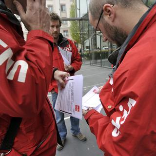 Unia se prépare à un piquet de grève devant le siège de Merck Serono, ce mercredi 25 avril 2012. [Martial Trezzini]