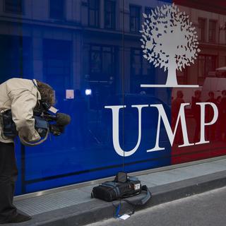 Un caméraman en train de filmer le logo du siège de l'UMP à Paris. [Ian Langsdon]