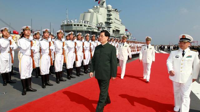 Le président chinois Hu Jintao inspecte la garde d'honneur sur le premier porte-avions chinois le 25 septembre 2012. [KEYSTONE - Zha Chunming]