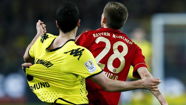 Robert Lewandowski (en jaune) à la lutte avec le Munichois Holger Badstuber: la finale s'annonce très serrée. [Reuters - Kai Pfaffenbach]