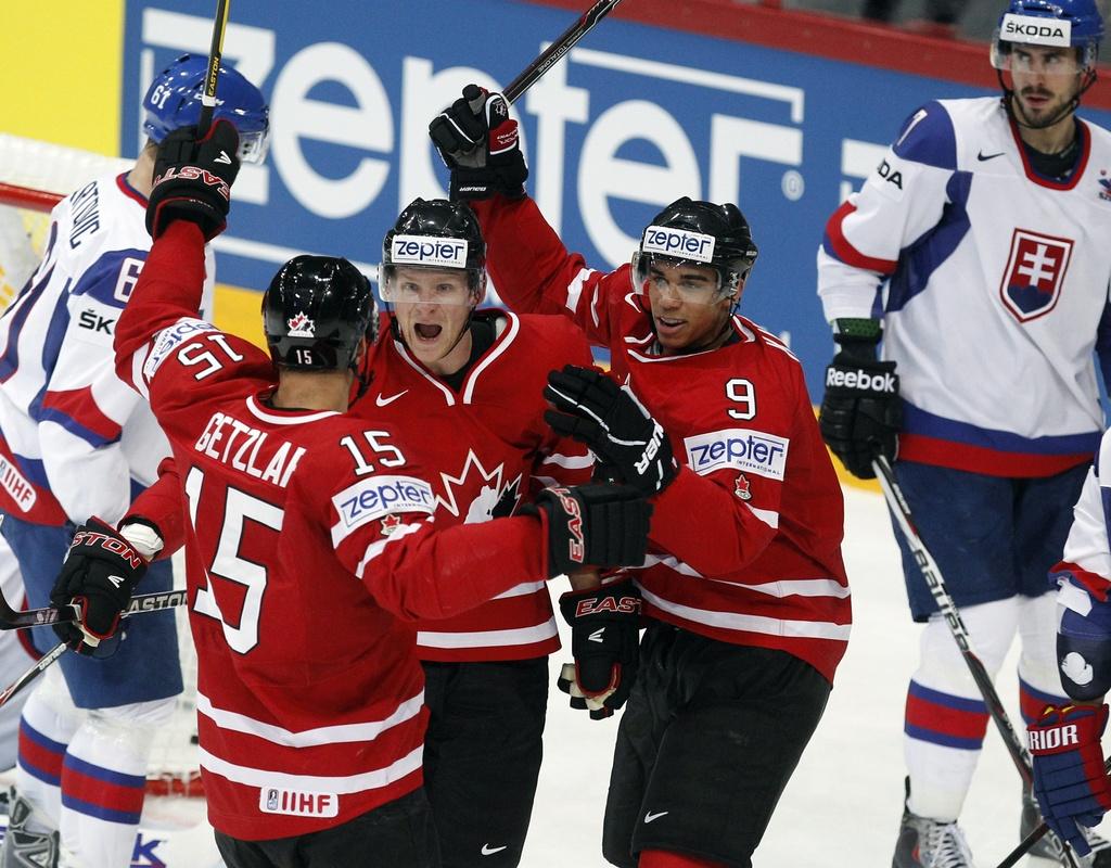 Correy Perry (au centre) félicité par ses coéquipiers. Le Canada [KEYSTONE - Dmitri Lovetsky]