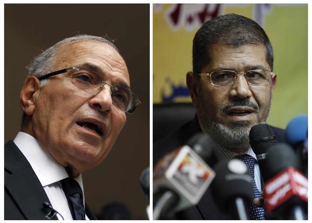 Ahmad Chafiq (à gauche) et Mohammed Morsi sont prêts pour le second tour de la présidentielle les 16 et 17 juin. [KEYSTONE - Khalil Hamra; Nasser Nasser]