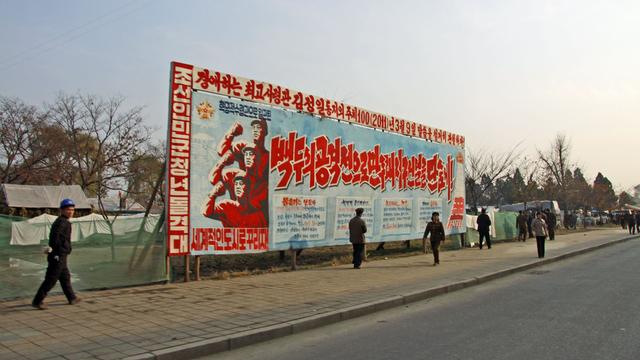 Pyongyang: les posters de propagande sont les seules touches de couleur dans un monde terne et gris. [Alain Arnaud]