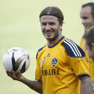 Los Angeles Galaxy's David Beckham (L) holds a ball during practice before their friendly match against the Philippines national football team Azkals at the Rizal Memorial football stadium in Manila December 2, 2011. Major League Soccer champion LA Galaxy is visiting Manila for three days as part of their Asian tour. REUTERS-Cheryl Ravelo (PHILIPPINES - Tags: SPORT SOCCER) [Reuters - Cheryl Ravelo]