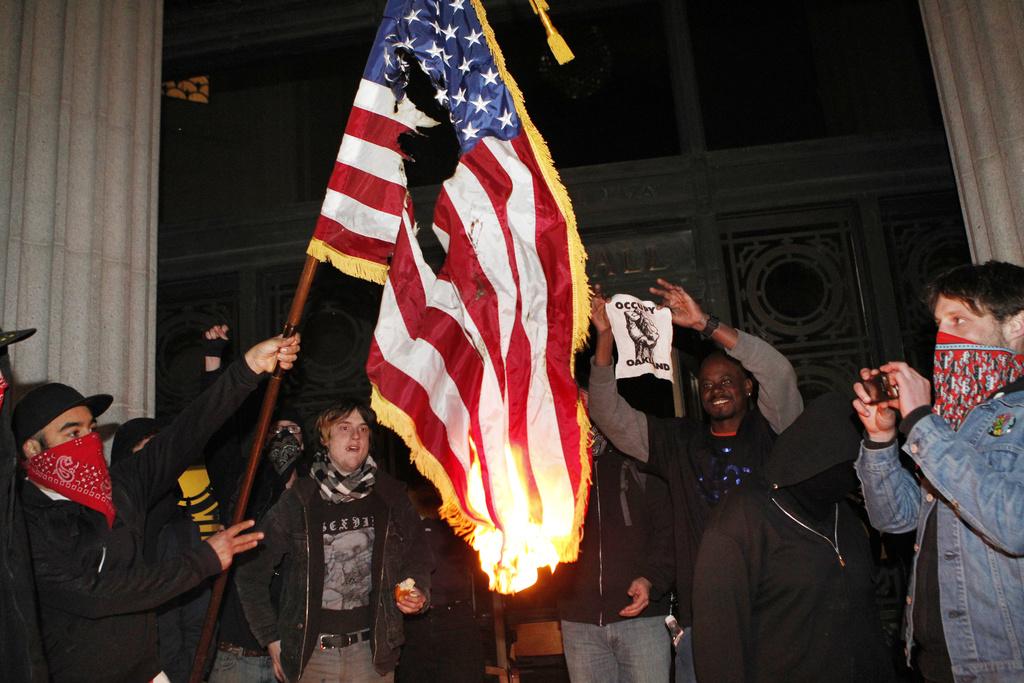 Les manifestants ont brûlé un drapeau américain dans l'hôtel de ville. [Beck Diefenbach]