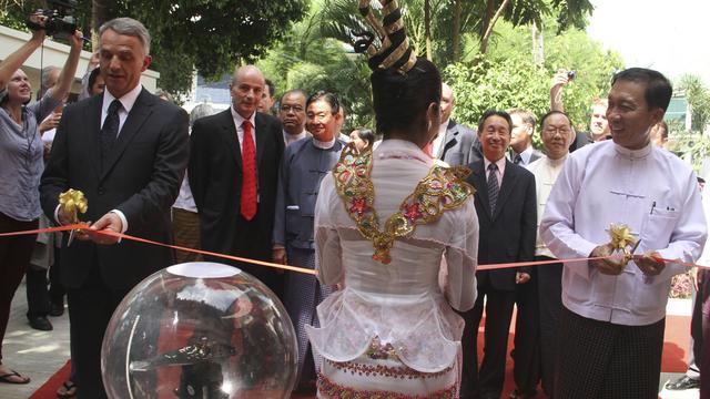 Didier Burkhalter coupant le ruban rouge lors de la cérémonie d'ouverture de l'ambassade de Suisse en Birmanie. [AP Photo]