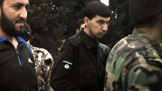 Un homme portant les couleurs d'Al-Qaida parmi des rebelles syriens en mai 2012 à Azzara. [Joseph Eid]
