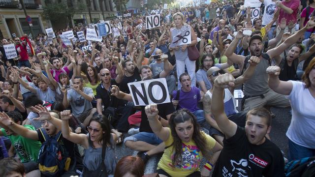 Les manifestants se sont assis en pleine rue pour marquer leur protestation. [REUTERS - Juan Medina]