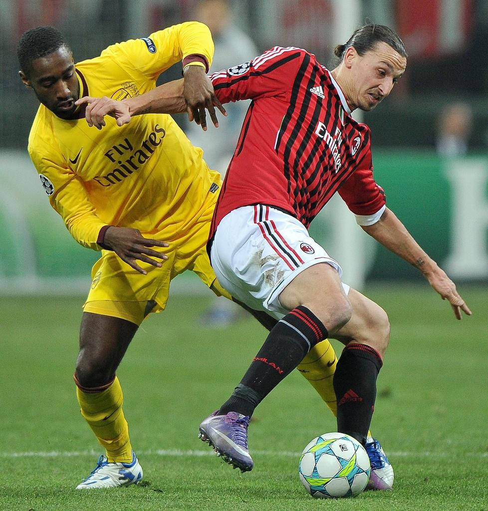 epa03107817 AC Milan Swedish forward Zlatan Ibrahimovic (R) vies for the ball with Arsenal defender Johan Djourou during their Champions League round of sixteen first leg match between AC Milan and Arsenal at the Giuseppe Meazza stadium in Milan, Italy, 15 February 2012. EPA/DANIEL DAL ZENNARO [KEYSTONE - Daniel Dal Zennaro]