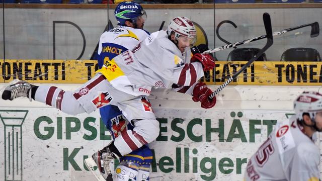 Der Genfer Eric Walsky, vorne, checkt den Davoser Tim Ramholt, beim Eishockey Meisterschaftsspiel der National League A zwischen dem HC Davos und Geneve Servette, am Sonntag, 22. Januar 2012, in der Vaillant Arena in Davos. (KEYSTONE/Juergen Staiger). [KEYSTONE - Juergen Staiger]