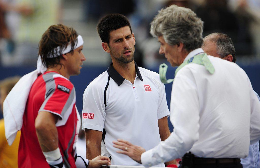 Brian Earley, le juge-arbitre, vient demander à Ferrer et Djokovic de quitter le court... [Keystone - JASON SZENES]