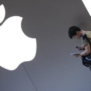 Un client utilise sa tablette numérique iPad à l'extérieur d'une boutique Apple à Shanghai le 28 juin 2012