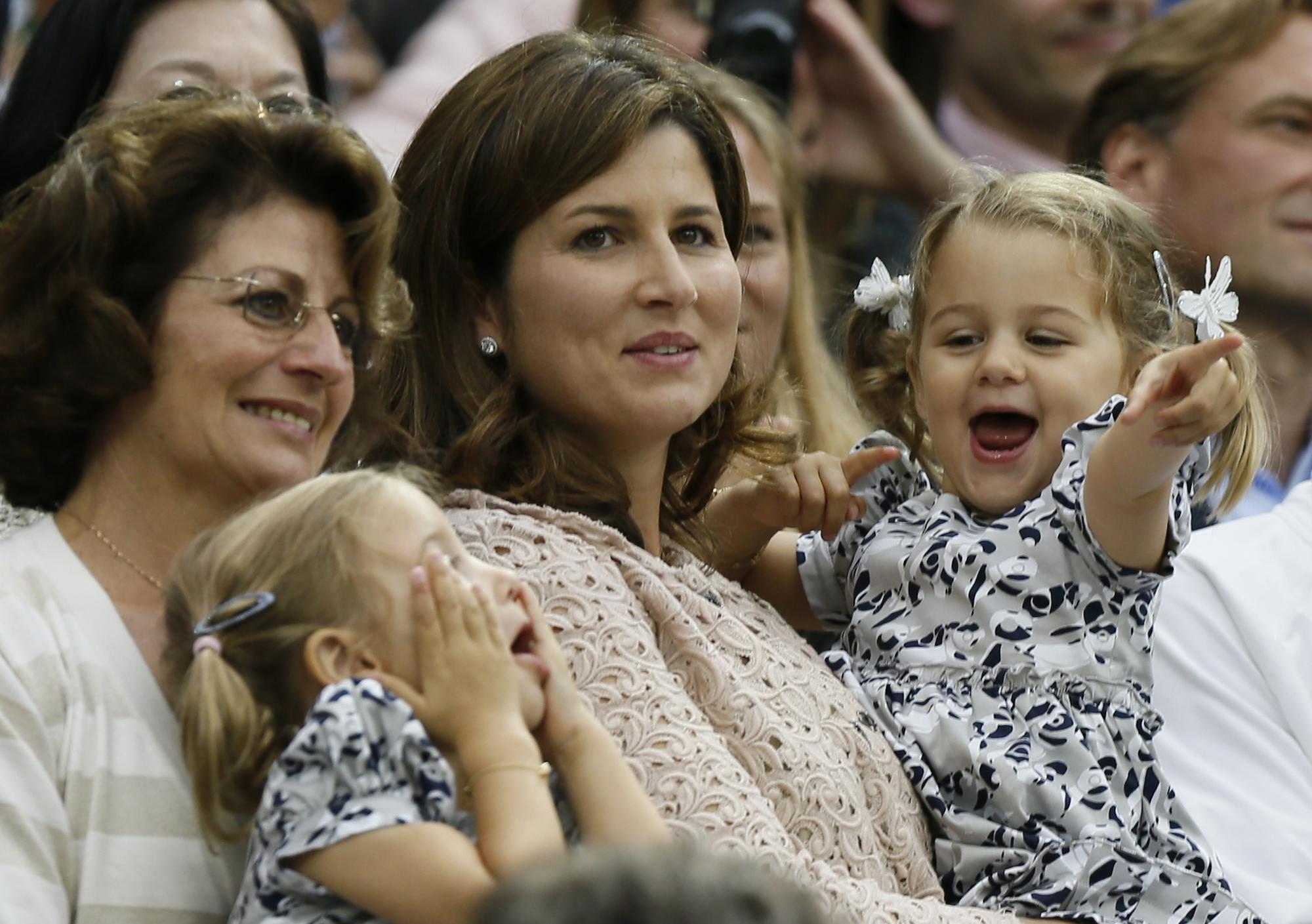 The wife of Roger Federer of Switzerland, Mirka Federer (C) with their two-year-old twins Charlene Riva and Myla Rose, celebrates after Federer defeated Andy Murray of Britain in their men's singles final tennis match at the Wimbledon Tennis Championships in London July 8, 2012. REUTERS/Stefan Wermuth (BRITAIN - Tags: ENTERTAINMENT SOCIETY SPORT TENNIS) [REUTERS - Stefan Wermuth]