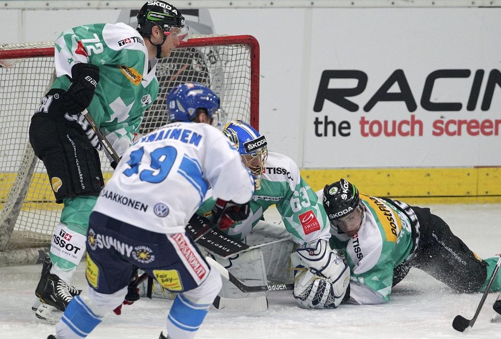 Switzerland's Patrick von Gunten, goalkeeper Leonardo Genoni and Robin Grossmann, from left, fights for the puck against Finland's Vali-Matti Savinainen, center front, during an Ice Hockey test game between Switzerland and Finland in Arosa, Switzerland, Friday April 6, 2012. (KEYSTONE/Arno Balzarini) [Arno Balzarini]