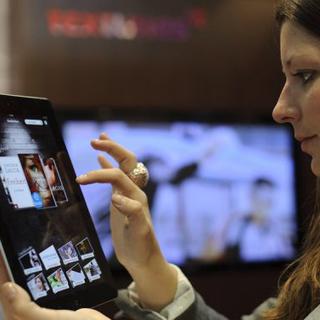 Une jeune femme manipule une tablette numérique