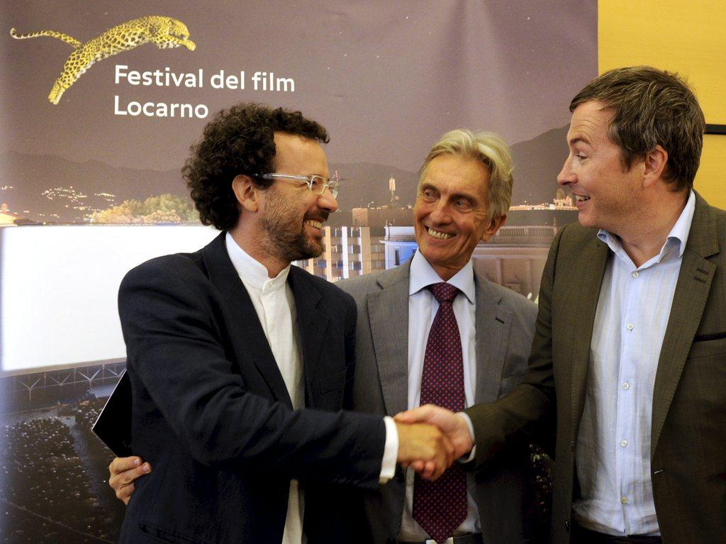 Passation de pouvoir entre Olivier Père (à droite) et Carlo Chatrian (à gauche) sous les yeux du président du festival Marco Solari. [Karl Mathis]