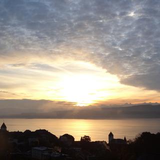 Lever de soleil jeudi au-dessus du Lac de Neuchâtel, prise depuis Grandson. On voit des cirrus et l'arrivée de quelques nuages comme des moutons. Sur le lac, on voit des vapeurs formées par l'eau plus chaude que l'air. La nuit était sans nuage et il faisait -1°C à notre thermomètre. [Caroline Rupp (9 ans)]