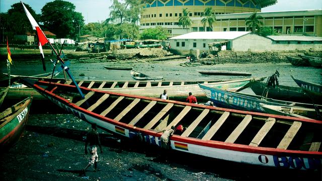 Les migrants clandestins guinéens rejoignent les bateaux des passeurs qui les transporteront en Europe à bprd des bateaux de pirogues du port de Boulninet à Conakry.