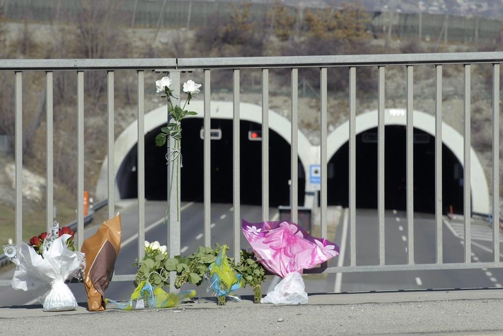 Des gerbes de fleurs ont été déposées sur un pont à l'entrée du tunnel de Sierre, où a eu lieu le drame. [Laurent Gilliéron]