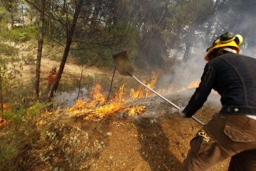 Le feu était toujours actif lundi dans la région à Torre de Maçanes. [KEYSTONE - EPA/MANUEL LORENZO]