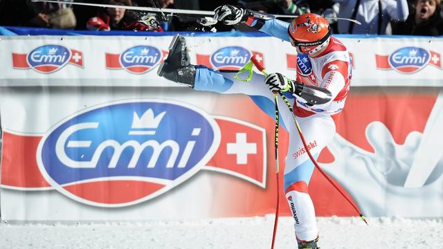 Cuche l'acrobate déchausse ses skis à sa manière. [KEYSTONE - SAMUEL TRUEMPY]