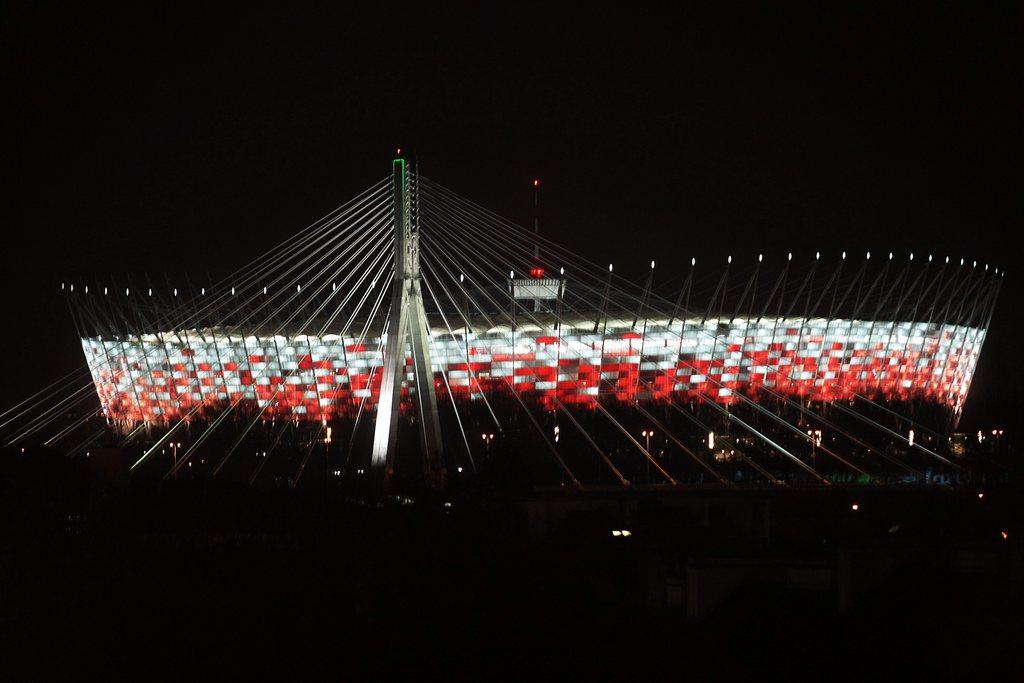 epa03061433 The in white-red national colors illuminated Polish National Stadium in Warsaw, Poland, late 15 January 2012. The stadium will hold the opening game of soccer UEFA EURO 2012 in June 2012. EPA/Leszek Szymanski POLAND OUT [KEYSTONE - Leszek Szymanski]