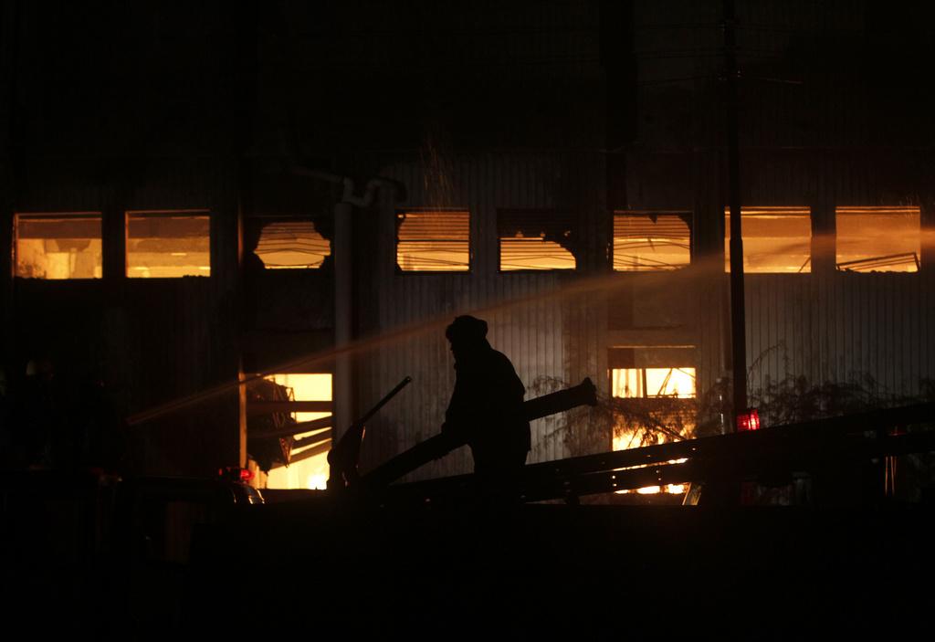 Les pompiers n'ont pas réussi à sauver les victimes coincées dans le sous-sol de l'usine en feu, à Karachi, au Pakistan. [KEYSTONE - Shakil Adil]