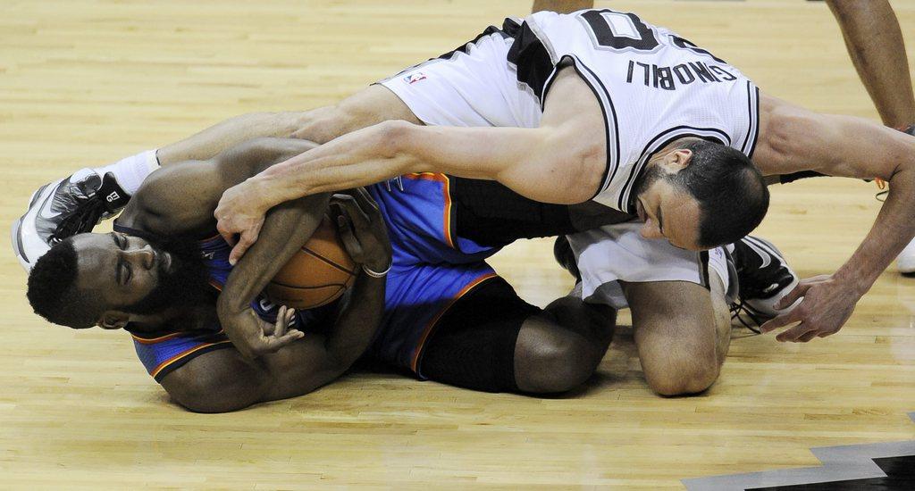 James Harden (en bleu) tente de piquer le ballon à Manu Ginobili, en vain. [Keystone - Darren Abate]