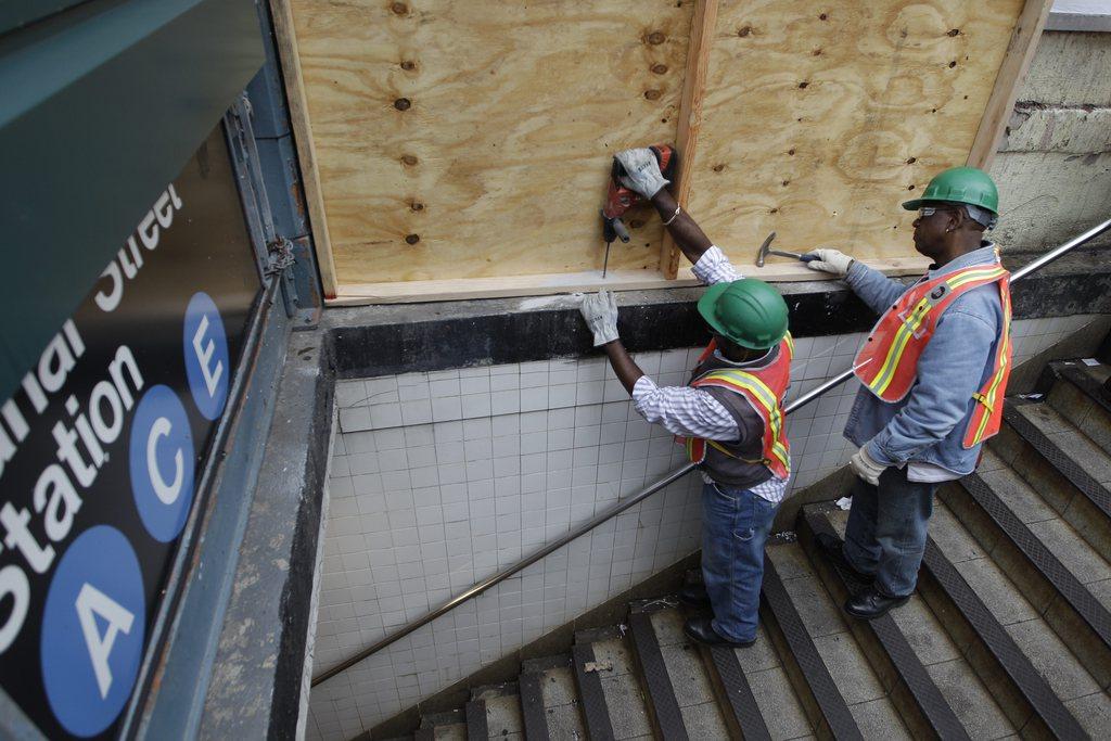 Des ouvriers s'activent pour protéger une bouche du métro new yorkais qui sera fermé dès dimanche soir. [Mary Altaffer]