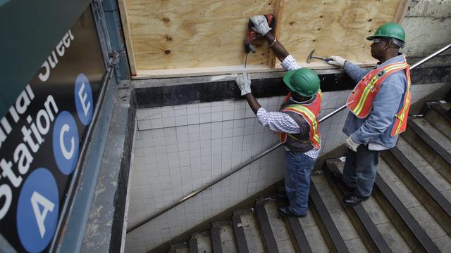 Des ouvriers s'activent pour protéger une bouche du métro new yorkais qui sera fermé dès dimanche soir. [Mary Altaffer]