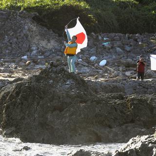 20152: des militants nationalistes brandissent le drapeau japonais sur l'une des îles Senkaku. [AP Photo/Kyodo News]