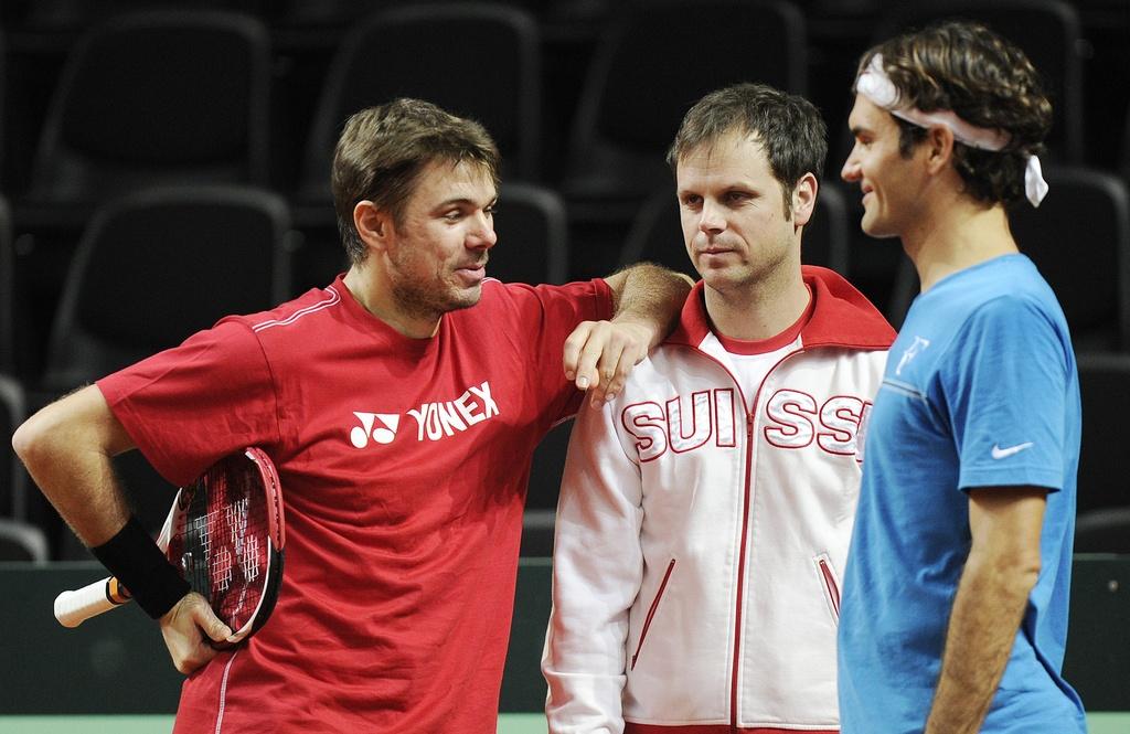 Swiss Davis Cup tennis player Roger Federer, right, and Swiss Davis Cup tennis player Stanislas Wawrinka, left, chat with Swiss Davis Cup team captain Severin Luethi, center, during a training session in the Forum Arena in Fribourg, Switzerland, Wednesday, February 8, 2012. Switzerland faces US in the World Group first round. (KEYSTONE/Jean-Christophe Bott) [Jean-Christophe Bott]