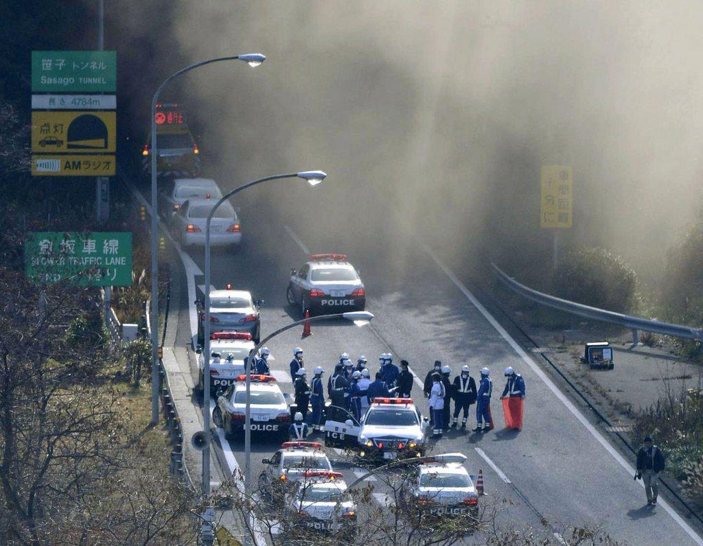 De la fumée s'échappait du tunnel dimanche alors que les secours tentaient de s'organiser. [KEYSTONE - AP Photo/Kyodo News]