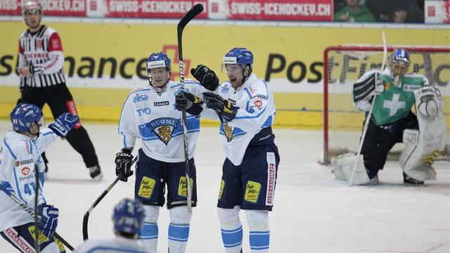 Finland's player, left, celebrated after winning score to 2-3 against Switzerland's goalkeeper Leonardo Genoni, right back, during an Ice Hockey test game between Switzerland and Finland in Arosa, Switzerland, Friday April 6, 2012. (PHOTOPRESS-Arno Balzarini) [KEYSTONE - Arno Balzarini]