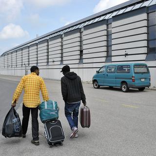 Deux demandeurs d’asile repartent devant le centre de requérants de La Chaux-de-Fonds en mai 2011. [Sandro Campardo]