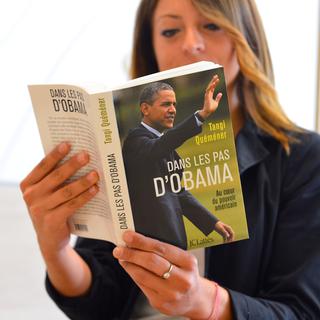 Une femme lit le dernier ouvrage de Tangi Quéméner, consacré à Barack Obama. [Miguel Medina]