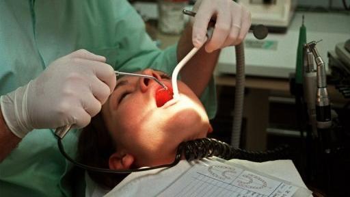 Un chirurgien-dentiste soigne une patiente