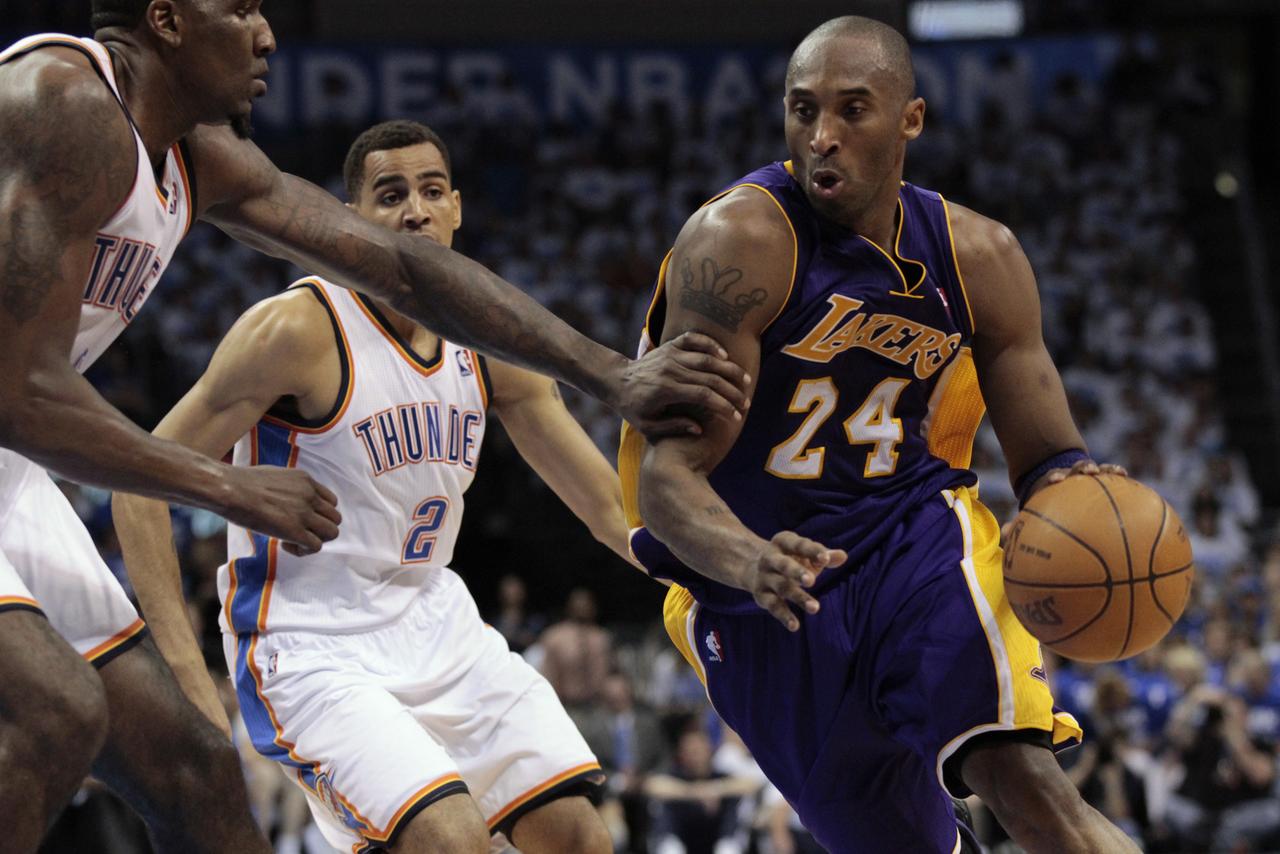 Los Angeles Lakers' Kobe Bryant (R) drives past Oklahoma City Thunder's Kendrick Perkins (L) and Thabo Sefolosha during Game 2 of the NBA Western Conference semi-finals in Oklahoma City, Oklahoma May 16, 2012. REUTERS/Steve Sisney (UNITED STATES - Tags: SPORT BASKETBALL) [Steve Sisney]