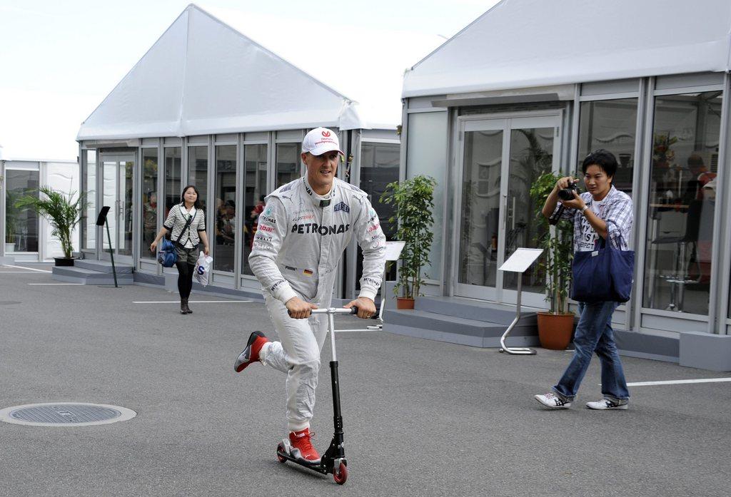 epa03423049 German Formula One driver Michael Schumacher of Mercedes AMG rides a scooter in the paddock after the qualifying session at the Suzuka Circuit in Suzuka, western Japan, 06 October 2012. The Japan Formula One Grand Prix that will be held on 07 October. EPA/FRANCK ROBICHON [Franck Robichon]