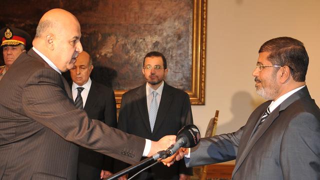 Le vice-président Mahmoud Mekki (g.), ici photographié en août 2012 avec le président Mohamed Morsi, a annoncé sa démission en plein vote sur la nouvelle Constitution égyptienne. [AFP Photo/Ho/Egyptian presidency - AFP Photo/Ho/Egyptian presidency]