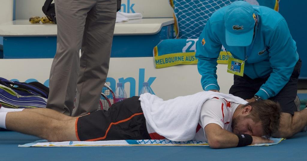 epa03068474 Stanislas Wawrinka of Switzerland gets a treatment during the third round men's singles match against Nicolas Almagro of Spain at the Australian Open Grand Slam tennis tournament in Melbourne, Australia, 20 January 2012. EPA/AHMAD YUSNI [Ahmad Yusni]