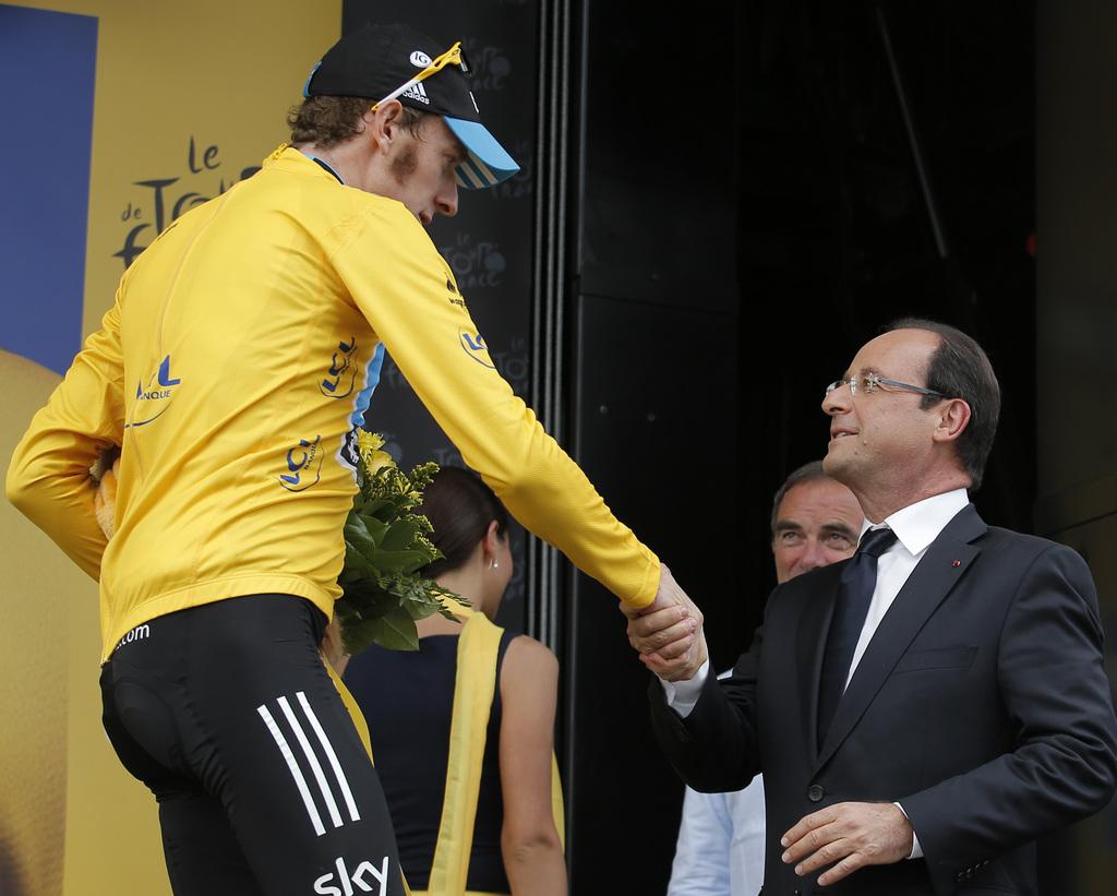 Wiggins conserve son maillot jaune en compagnie de François Hollande. [Christophe Ena]