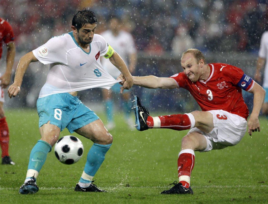 Switzerland's Ludovic Magnin, right, and Turkey's Nihat Kahveci, left, vie for the ball during the group A match between Switzerland and Turkey in Basel, Switzerland, Wednesday, June 11, 2008, at the Euro 2008 European Soccer Championships in Austria and Switzerland. (AP Photo/Dusan Vranic) [Dusan Vranic]