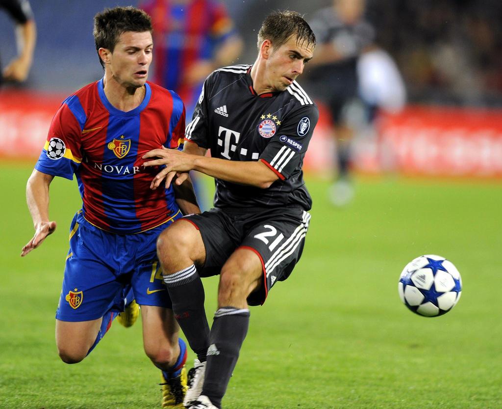 Valentin Stocker, ici à la lutte avec le Munichois Philipp Lamm, a marqué le but bâlois victorieux pour Bâle contre le Bayern de Munich en Champions League fin février 2012. [KEYSTONE - Walter Bieri]