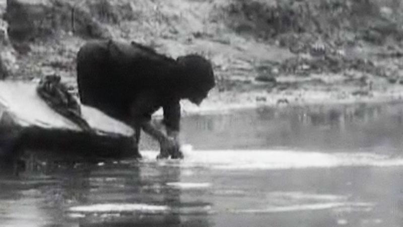 Une femme lave des vêtements au bord du Nil. [RTS]