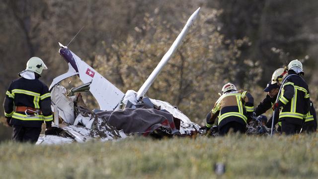 Firefighters inspect the wreckage of a small plane that crashed on a meadow outside Tatroz [Pascal Lauener]