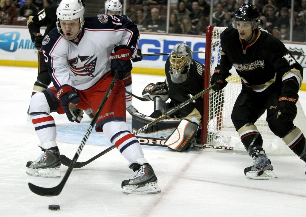 Columbus Blue Jackets right wing Derek Dorsett (15) controls the puck as Anaheim Ducks defenseman Luca Sbisa (5), of Italy, and goalie Jonas Hiller (1), of Switzerland, defend during the first period of an NHL hockey game in Anaheim, Calif., Sunday, Jan. 8, 2012. (AP Photo/Alex Gallardo) [Alex Gallardo]